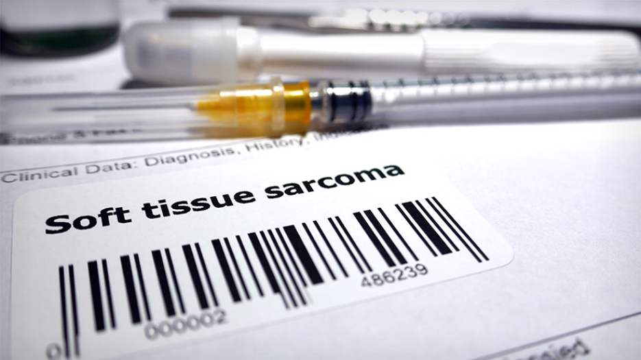Image of a syringe on top of a paper with a barcode that says 'soft tissue sarcoma'
